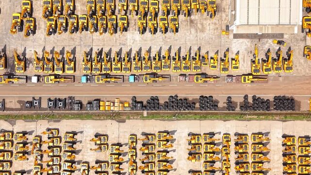 Aerial view of rows of yellow excavators parked in an industrial manufacturing yard in Sriperumbudur, Tamil Nadu, India.