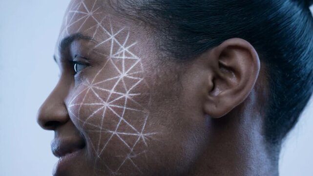 Young woman in sci fi portrait looks ahead with calm expression, white network lines tracing face. Young woman gradually turns to profile, revealing smooth skin, tied hair, and minimalist blue