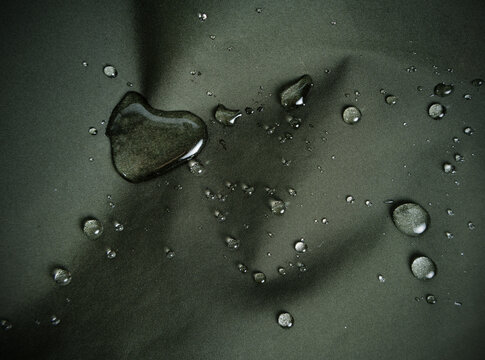Water drops on dark green hydrophobic textile close-up