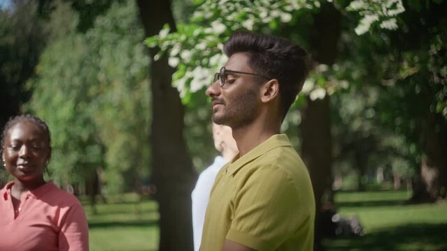 Multiethnic group practicing outdoor group psychotherapy and breathing exercises in park. Clip ideal for mental health awareness campaigns and wellness retreats