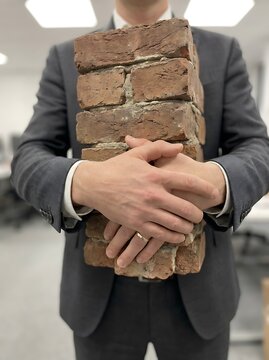 Person holding red bricks in hands construction