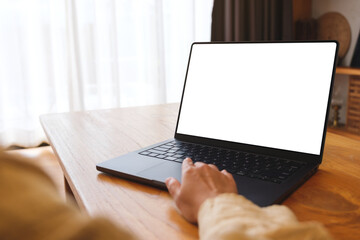 Obraz na płótnie Canvas Mockup image of a woman working on laptop computer with blank screen at home