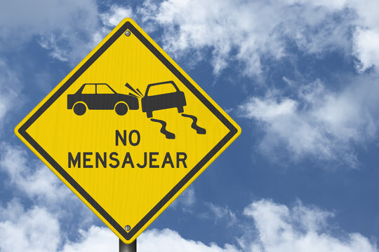 No texting Mensajear yellow warning sign with sky for distracted driving