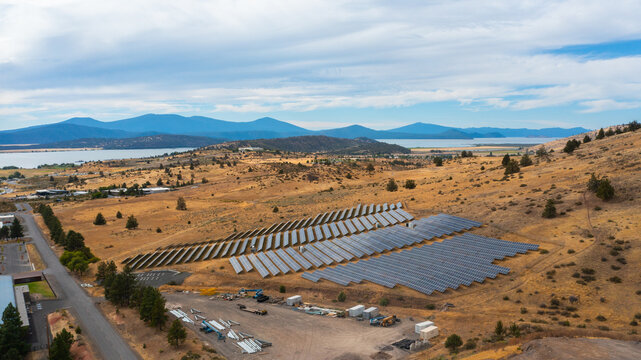 Aerial view of the Oregon Tech solar panel array situated on a dry hillside with a view of the lake and mountains in the background in Klamath Falls, Oregon, United States.
