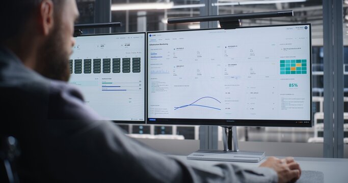 IT Professional Investigates Critical System Error Inside Data Center, Using Dual Monitors to Analyze Infrastructure Performance, Troubleshoot Servers, Maintain Reliability, and Prevent Downtime.