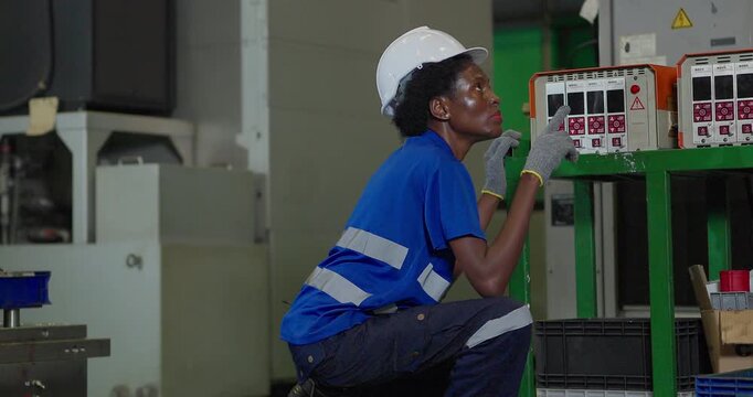 Technician connecting hot runner controller and hydraulic hoses to injection mould in factory