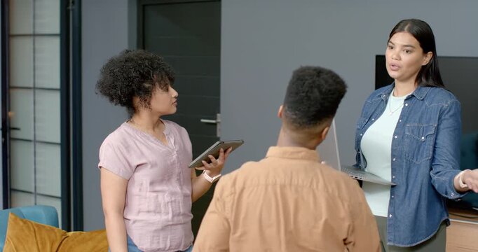 African American women and teenage son listening as right woman explaining laptop alert, tablet