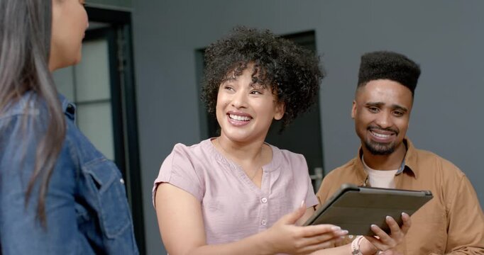 African American coworkers presenting tablet in office, celebrating after review and high-fiving