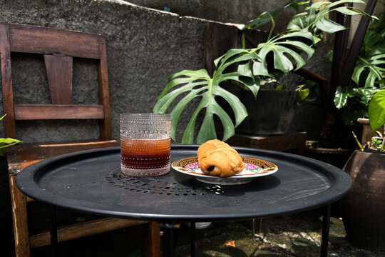 Outdoor Table with Bread and Beverage in Tropical Garden Setting