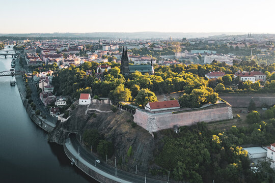 Aerial view of Vysehrad fortress with its historic basilica, lush green park, and stone fortifications overlooking the Vltava River in Prague, Prague, Czechia.