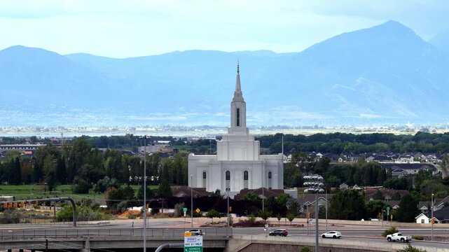 Orem, Utah, United States - 30 August 2026: Aerial view of the Orem Utah Temple of the Church of Jesus Christ of Latter-day Saints surrounded by lush trees and mountains.