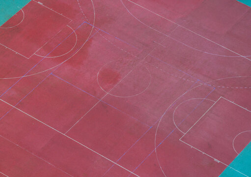 Aerial view of a red basketball court with white lines and blue borders in Gdansk, Pomeranian Voivodeship, Poland.
