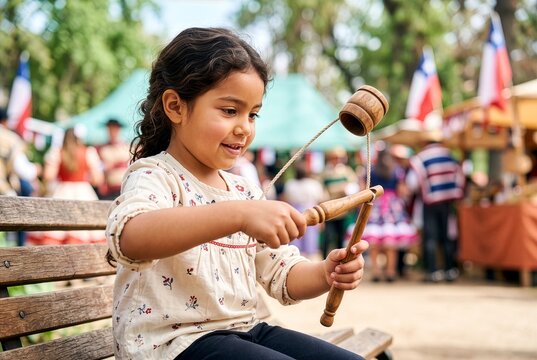 Chilean child concentrating while playing a traditional emboque game during Fiestas Patrias.