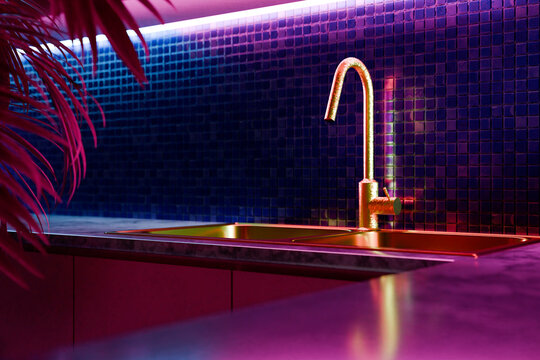 Modern kitchen interior with neon lights, mosaic tile, marble countertop and gold faucet sink. Contemporary creative interior design. Minimalist luxury architecture concept idea. 3d render