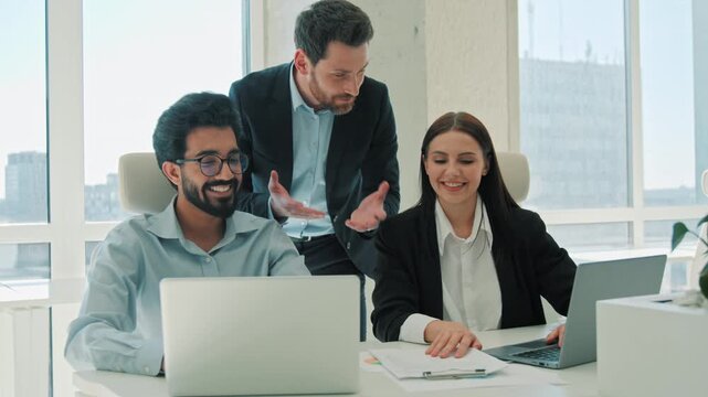 Happy multiethnic business team celebrating successful deal indoor office leader sharing good news with colleagues businessman businesswoman teamwork achievement workers discussing contract together