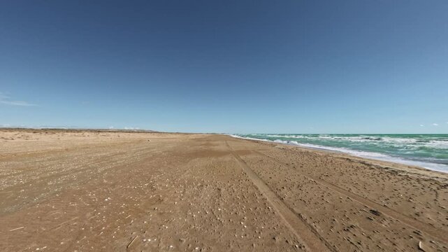 Forward tracking shot along a sandy beach coastline