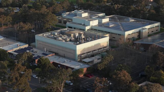 Melbourne, VIC, Australia - 03 September 2026: Aerial view of the Knox Data Centre with industrial rooftops, cooling units, solar panels, and surrounding trees.