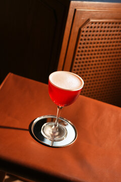 Red Alcoholic Sour Cocktail with Foam in Stemmed Glass Close Up