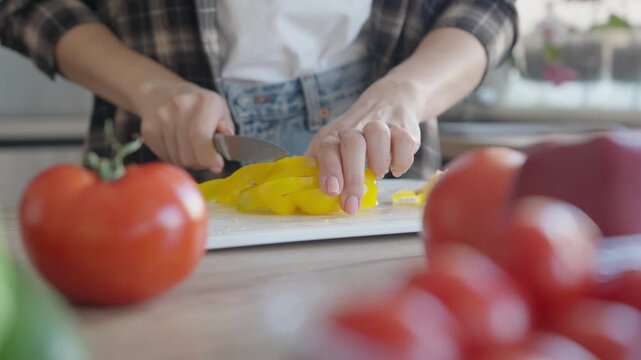 Close Up Of Woman Slicing Yellow Bell Pepper For Fresh Salad