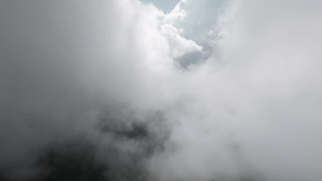 Aerial view of winding road through clouds and mountains