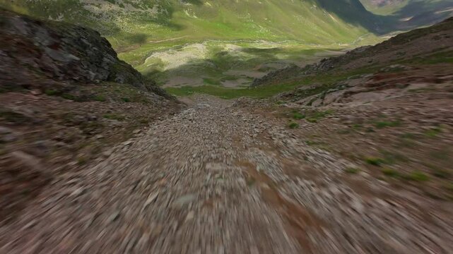 Rapid Descent Down Rocky Mountain Slope to Valley