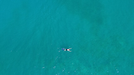 A man in a mask and flippers is swimming in clear, transparent water at the sea © Павел Чигирь