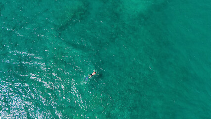 A man in a mask and flippers is swimming in clear, transparent water at the sea © Павел Чигирь