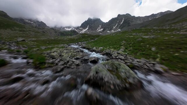 Fast aerial flight over mountain stream and rocks