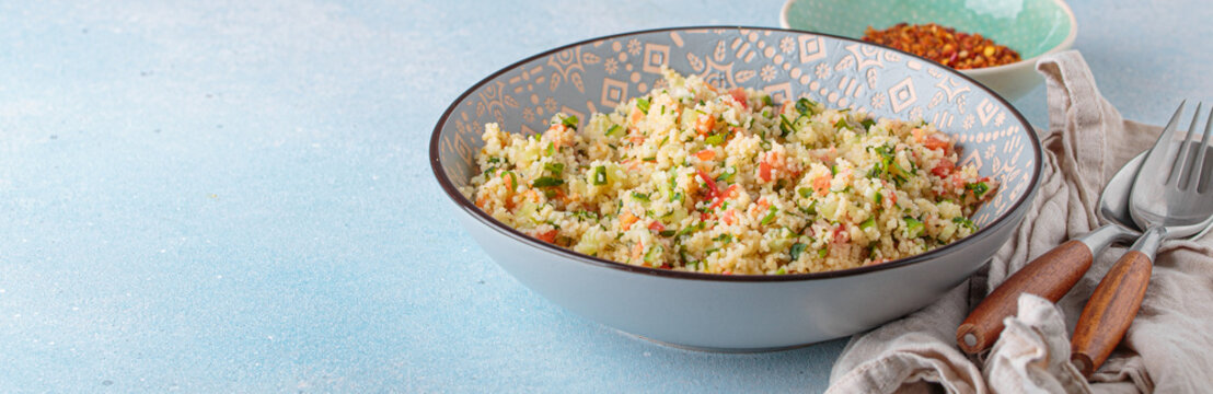 Tabbouleh salad couscous vegetables bowl Middle Eastern blue background copy space
