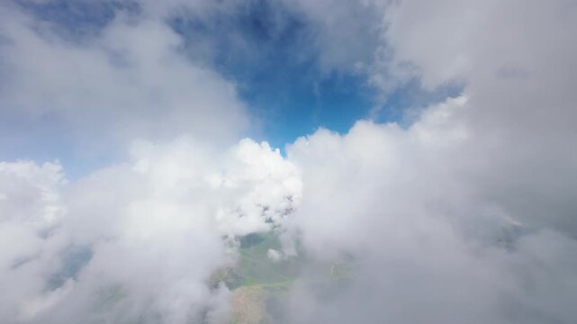 Aerial view of clouds and green mountainous landscape