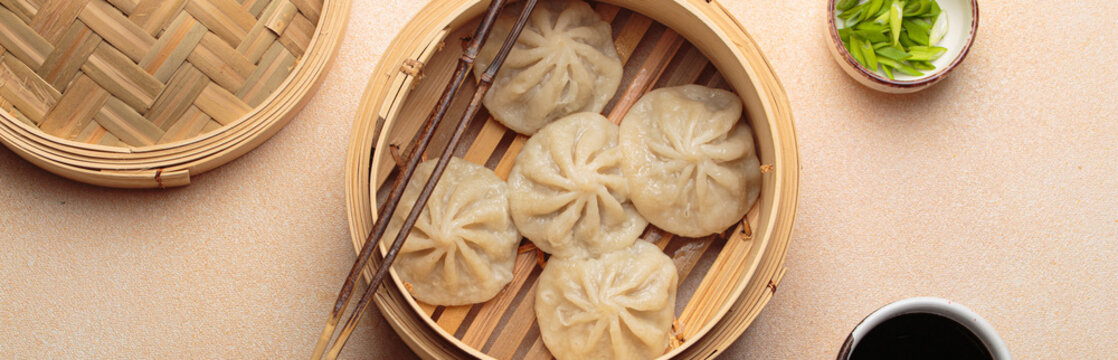 Chinese food dim sum bao dumplings bamboo steamer chopsticks beige background