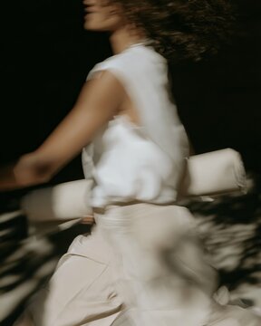 Woman in white outfit captured mid movement with camera blur