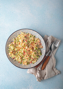 Tabbouleh salad couscous vegetables bowl Middle Eastern blue background top view