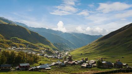 Fototapeta premium Landscape photograph of Ushguli village with Svan towers in mountain valley under blue sky in Svaneti Georgia.