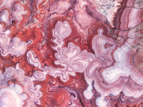 Aerial view of the colorful, layered clay formations of the Hanksville Bentonite Hills, showcasing intricate patterns and vibrant red and purple hues in Hanksville, Utah, United States.