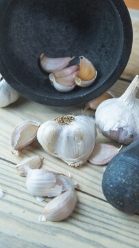 Cabezas de ajo y dientes de ajo crudo dentro de un mortero