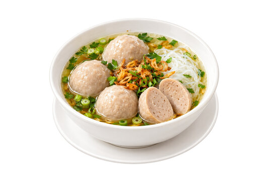 Indonesian meatball soup bakso served with rice vermicelli, clear broth, fried shallots, and celery in a white bowl, isolated on a transparent background.