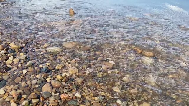Clear River Water Waves Gently Breaking Over Small Shoreline Stones