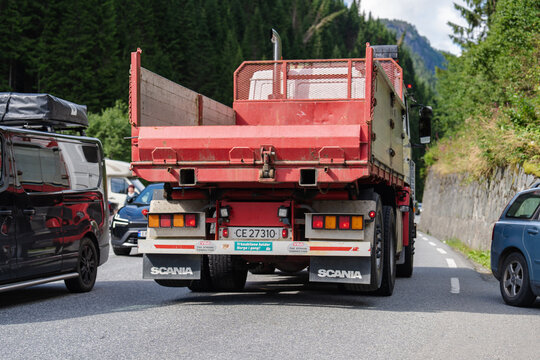 August 16, 2026, Skare, Norway - Rear view of a red Scania dump truck on a road with other vehicles in a mountainous area