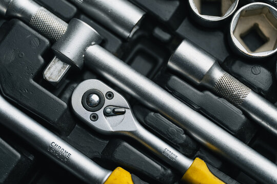 Close up shot of mechanical tools, ratchet handle and extension bars in organized toolbox case. Garage repair kit, workshop equipment and car service concept.	
