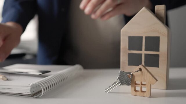 Architect drafting plans holding house model key