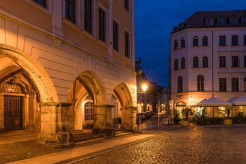 Fototapeta premium Stunning night cityscape of Görlitz, Germany. Beautifully illuminated historic Old Town, medieval architecture, and bright street lights highlighting the rich cultural heritage at dusk.