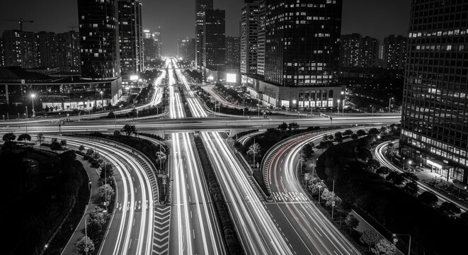 Night aerial panorama of a bustling city highway system with car light trails showcasing urban transportation