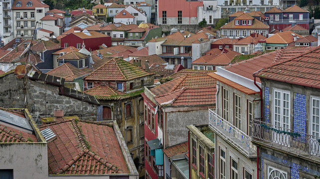 View of the historic rooftops of Porto with traditional terracotta tiles, intricate building facades, and classic architectural details in Porto, Porto District, Portugal.