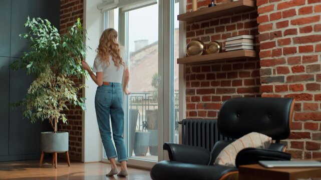 Happy active joyful Caucasian middle-aged woman funny dancing move satisfied at home cheerful joyous candid female dance move listening music celebrating relocation moving day enjoying weekend indoors
