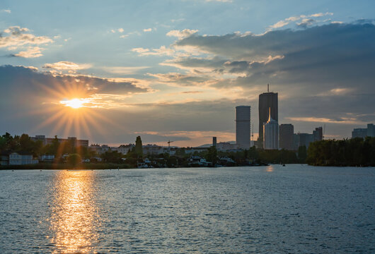 View of Donau City skyline featuring DC Tower 1 and Hochhaus Neue Donau reflecting in the Danube river during a golden sunset Wien, Wien, Austria.
