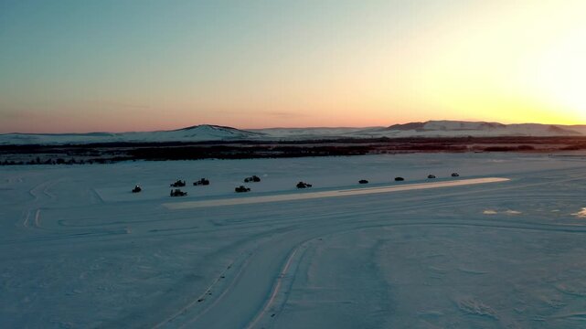 Winter Vehicle Convoy Crossing Snow at Sunset