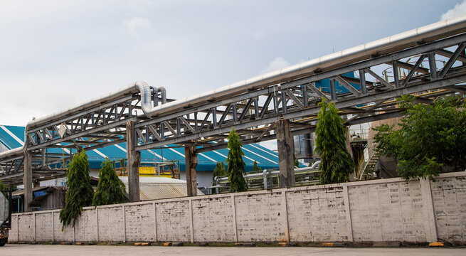 Industrial steel pipe rack system on factory wall in chemical manufacturing plant.Pipeline bridge transport system for industrial facility and refinery plant