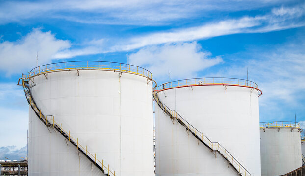 Crude Oil Industry, White Storage Fuel Gas Container Tanks in Petroleum Refinery Industrial Factory area against Blue Sky Background