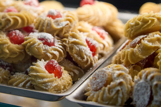 Assortment of delicious Sicilian pastries with almonds, chocolate drizzle, candied cherries and pistachio cream.